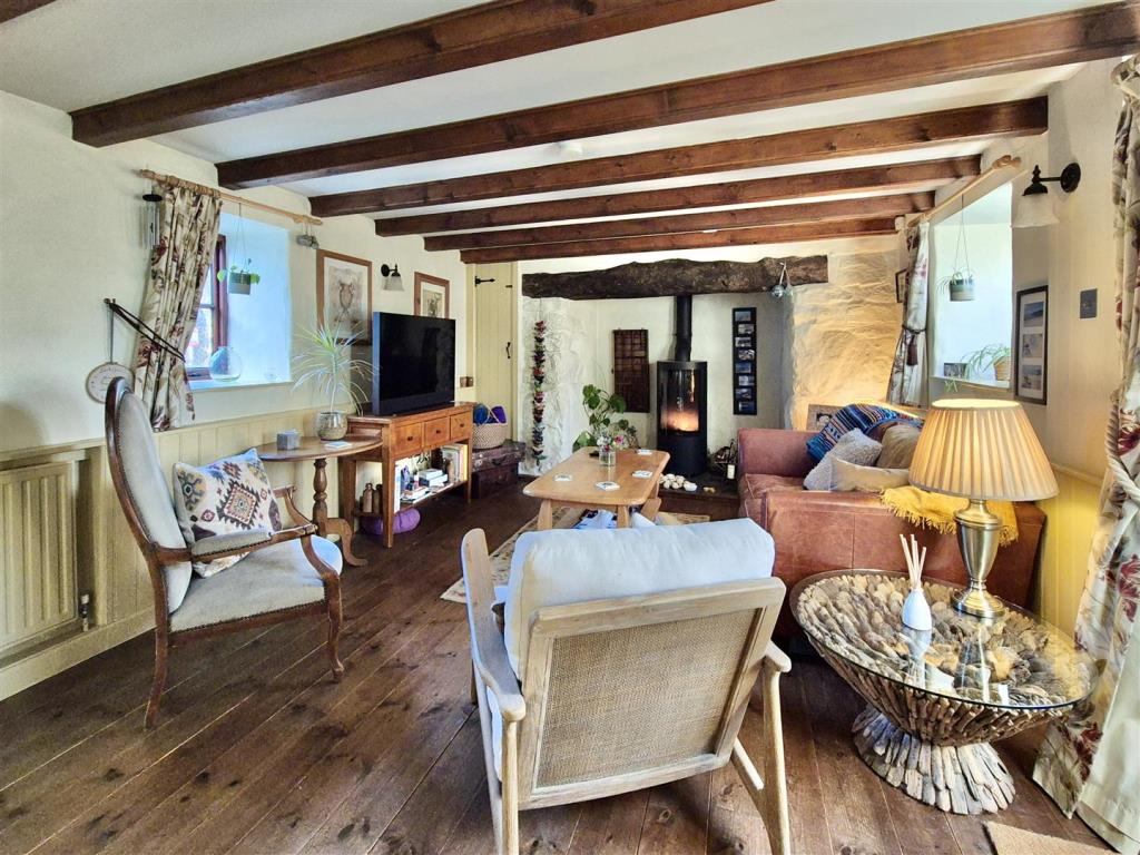 Lot: 109 - THATCHED DECEPTIVELY SPACIOUS DETACHED COTTAGE WITH GARDENS AND PARKING - Partial living room view